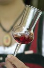 Closeup view of woman holding glass of Cornelian cherry liqueur — Stock Photo