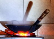 Vue rapprochée d'un wok sur une cuisinière à gaz — Photo de stock