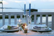 Покладений стіл зі свічками на пірсі в сутінках — стокове фото