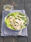 Салат Цезарь с авокадо, жареная курица и гренки на белой тарелке с вилкой — стоковое фото