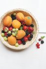 Корзина с летними абрикосами и ягодами — стоковое фото