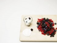 Fresh berries in heap on wooden board — Stock Photo