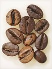Primer plano vista superior de diez granos de café secos - foto de stock