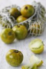 Green tomatoes in shopping net — Stock Photo