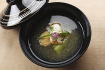 Dashi broth with vegetables in black pot — Stock Photo