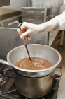Chef stirring melted chocolate — Stock Photo