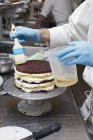 Chef brushing oil onto cake — Stock Photo