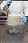 Konditor dekoriert einen Kuchen — Stockfoto