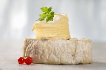 Camembert cheese with slice on top — Stock Photo