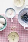 Closeup top view of blueberries, sugar and eggs — Stock Photo