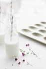 Botella de leche con flor - foto de stock
