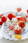 Rote und gelbe Tomaten mit Blüten — Stockfoto