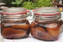 Closeup view of two jars of pears in cherry brandy — Stock Photo