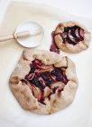 Two apple and blackberry galettes on white paper — Stock Photo