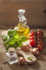 Un arreglo de cebollas, tomates, especias, albahaca y aceite de oliva - foto de stock