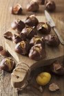 Chestnuts on wooden chopping board — Stock Photo