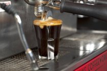 Espresso derramando da máquina em vidro — Fotografia de Stock