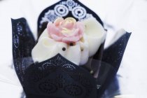 Vista close-up de praline elegante decorado com rosa em caixa de papel preto — Fotografia de Stock