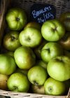 Green Bramley apples with price label — Stock Photo