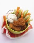 Nuggets de pollo con palitos de verduras y una salsa de mayonesa - foto de stock