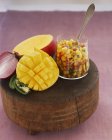 Mango salsa with red onions, sweetcorn and jalapeos on wooden desk — Stock Photo