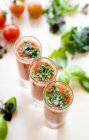 Cold tomato soup with basil in shot glasses — Stock Photo