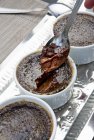 Closeup view of chocolate Creme brulee on spoon and in bowls — Stock Photo