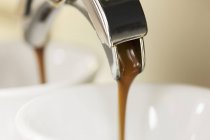 Espresso quente correndo em xícara — Fotografia de Stock