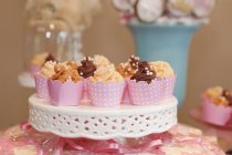 Cupcakes com caramelo, noz e cobertura de chocolate — Fotografia de Stock