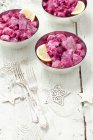 Herring salad with beetroot in bowls over wooden surface — Stock Photo