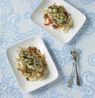 Draufsicht auf gegrilltes Hühnchen und Salate auf Tellern — Stockfoto