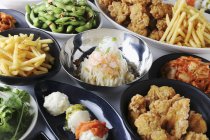 Vari piatti di partito: pollo fritto, fagioli di soia, patatine fritte e kimchi — Foto stock