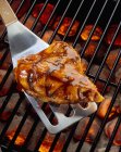 Closeup view of chicken breast on a spatula on a barbecue — Stock Photo