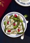 Asparagi verdi con crosta di semi di sesamo sul piatto su superficie scura — Foto stock