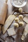 Vue du dessus de la pâte à boulettes avec farine, coupe-pâte et rouleau à pâtisserie — Photo de stock