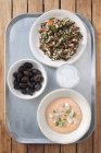 Greek mezze: taramasalata, olives and tabbouleh in bowls over tray — Stock Photo