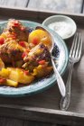 Moroccan chicken stew on plate with spoon over wooden tray — Stock Photo