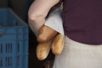 Donna che tiene tre baguette — Foto stock