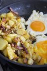 Pommes de terre frites au bacon et œufs frits dans une poêle — Photo de stock
