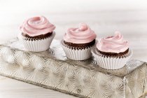 Шоколадные кексы с розовой глазурью — стоковое фото