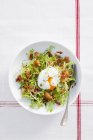 Top view of poached egg on lettuce with bacon and croutons — Stock Photo