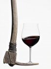 Red wine balanced on a pick axe — Stock Photo
