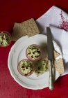 Вершки з авокадо з сушеними помідорами на білій тарілці з ножем — стокове фото