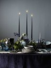 Une table de fête avec des fleurs décorées dans des tons sombres — Photo de stock