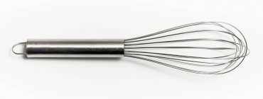 Closeup view of one whisk on white surface — Stock Photo