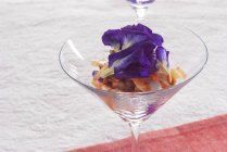 Closeup view of shrimp cocktail with butterfly pea flowers — Stock Photo