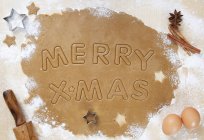 Верхний вид печенья тесто развернуто с Merry X-Mas вырезать слова — стоковое фото