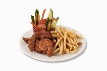Chicken nuggets with chips and vegetables on white plate — Stock Photo