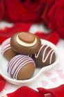 Chocolates em um prato em forma de coração — Fotografia de Stock