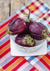 Fresh aubergines in bowl — Stock Photo